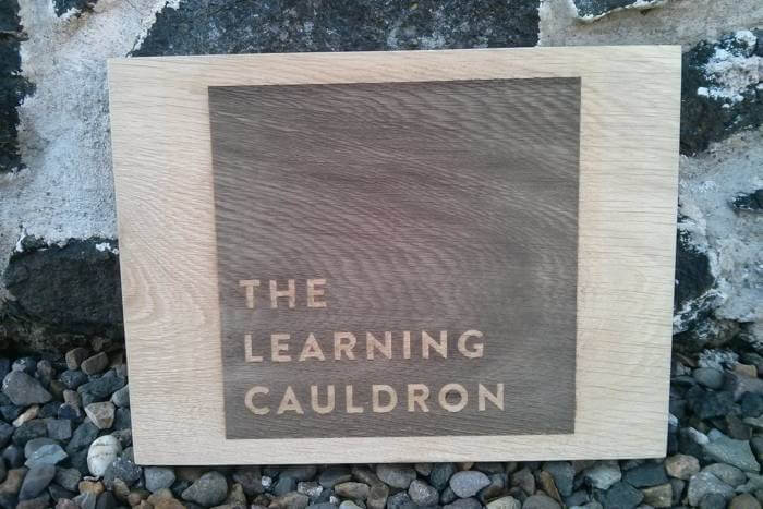 The Learning Cauldron oak sign
